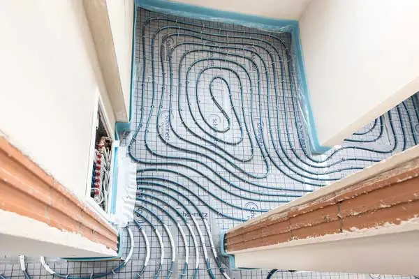 Hausmodell mit warmem Schal als Symbol für Heizungsmodernisierung